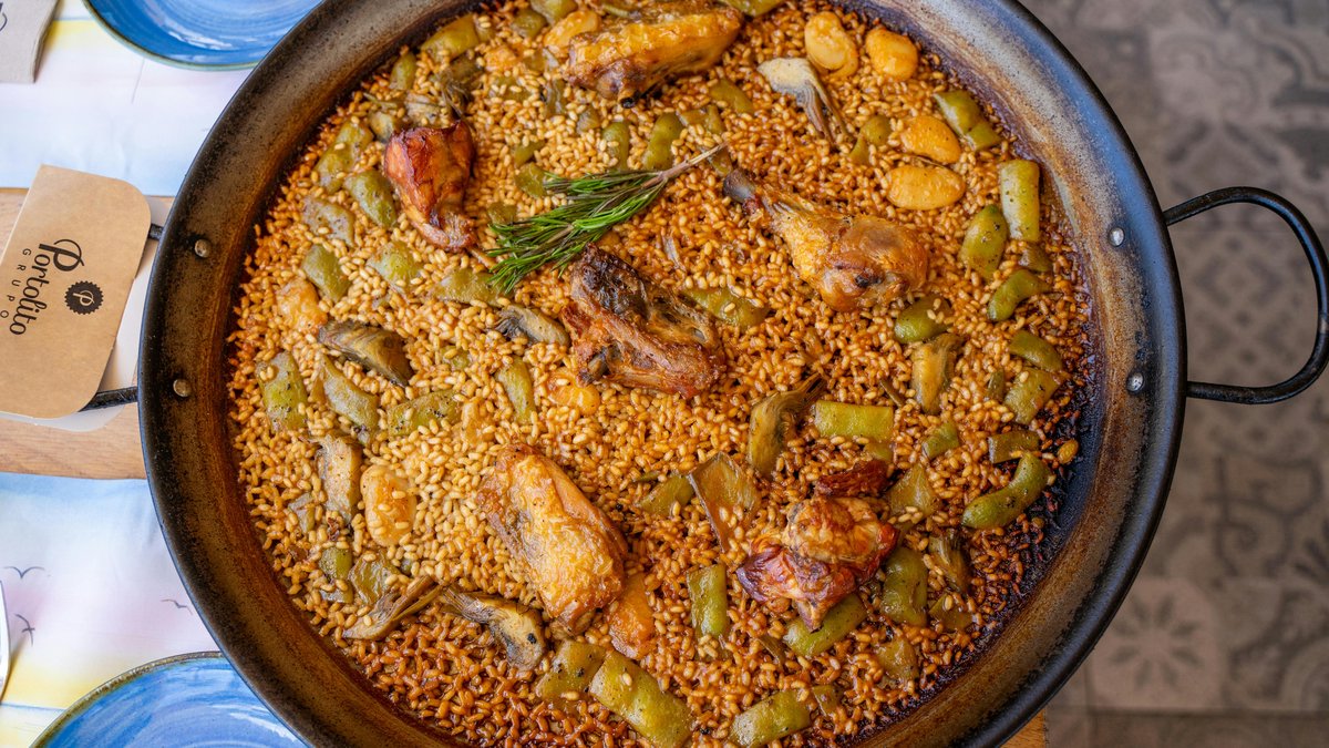 Paella valenciana tradizionale cotta in padella su fuoco a legna
