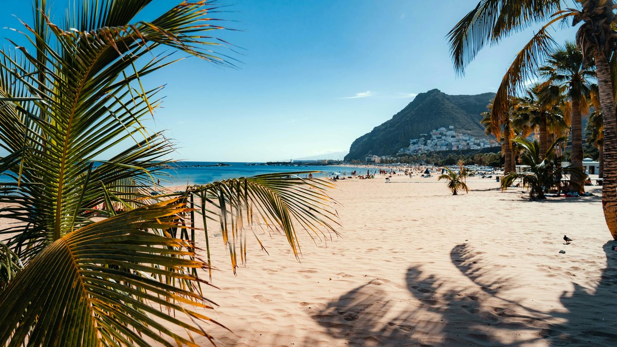 Spiaggia di Tenerife con cielo azzurro e mare calmo, la destinazione ideale tutto l'anno